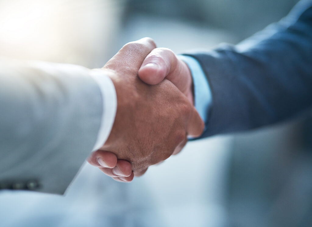 Cropped shot of two unrecognizable businessmen shaking hands in the office.
